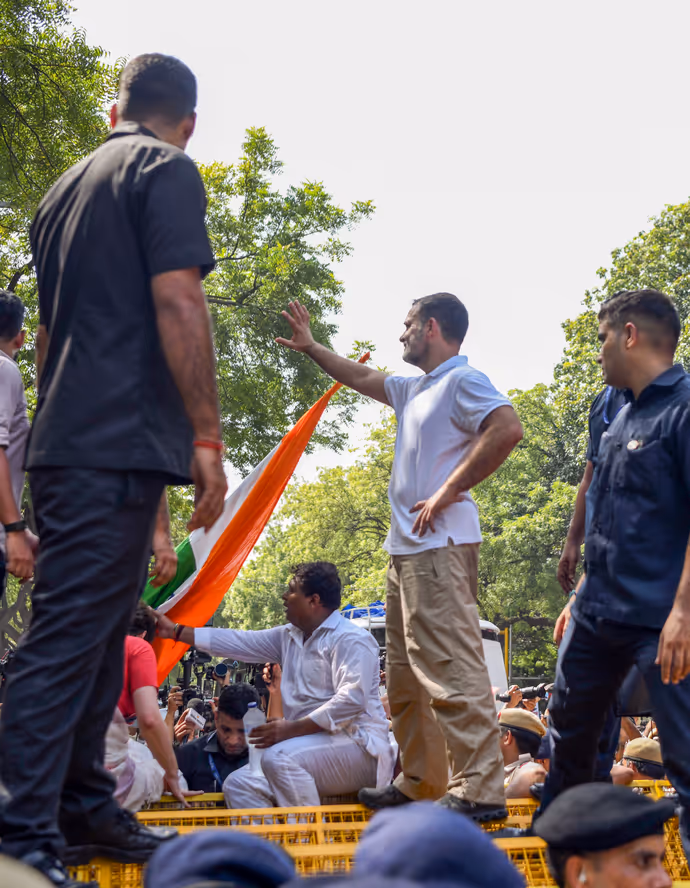 INDIA Bloc Protest की 15 तस्वीरें: राहुल गांधी ने बैरिकेड पर चढ़कर लहराया तिरंगा, प्रियंका संग पेड़ के नीचे बैठे