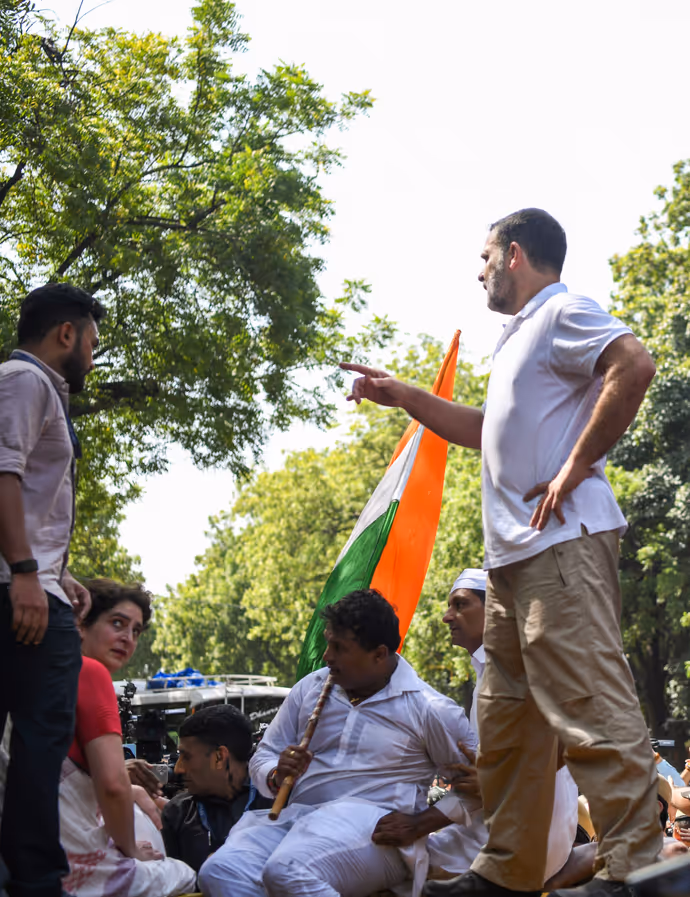 INDIA Bloc Protest की 15 तस्वीरें: राहुल गांधी ने बैरिकेड पर चढ़कर लहराया तिरंगा, प्रियंका संग पेड़ के नीचे बैठे