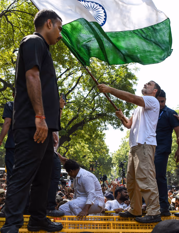 INDIA Bloc Protest की 15 तस्वीरें: राहुल गांधी ने बैरिकेड पर चढ़कर लहराया तिरंगा, प्रियंका संग पेड़ के नीचे बैठे