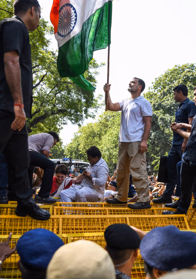 INDIA Bloc Protest की 15 तस्वीरें: राहुल गांधी ने बैरिकेड पर चढ़कर लहराया तिरंगा, प्रियंका संग पेड़ के नीचे बैठे