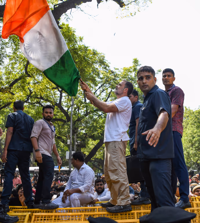 INDIA Bloc Protest की 15 तस्वीरें: राहुल गांधी ने बैरिकेड पर चढ़कर लहराया तिरंगा, प्रियंका संग पेड़ के नीचे बैठे