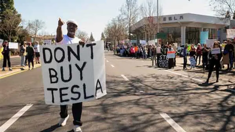 People protest against Tesla and Elon Musk outside of a Tesla dealership in Palo Alto, California (Image/Reuters)